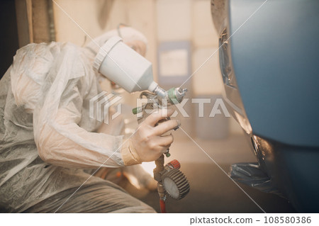 Car painter in protective clothes and respirator mask painting vehicle car 108580386