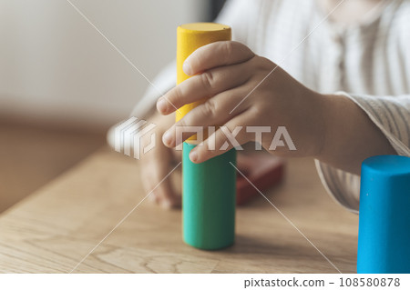 Child development. Montessori toy blocks and a child, a baby playing. Early development, kindergarten, childhood concept. Child development. Montessori toy blocks and a child, a baby playing. Early development, kindergarten, childhood concept. 108580878