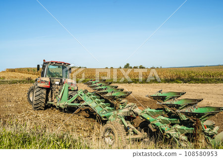 Tractor in the field. Agricultural machinery. Agricultural farm tractor during tillage of soil and field after harvest. 108580953