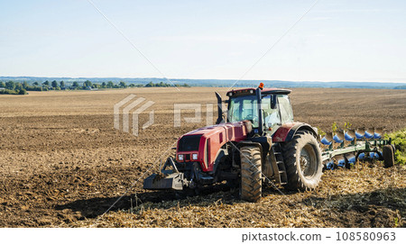 Tractor in the field. Agricultural machinery. Agricultural farm tractor during tillage of soil and field after harvest. Tractor in the field. Agricultural machinery. Agricultural farm tractor during tillage of soil and field after harvest. 108580963