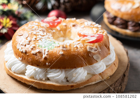 Individual Epiphany cake roscon de reyes with cream on wooden table Individual Epiphany cake roscon de reyes with cream on wooden table 108581202