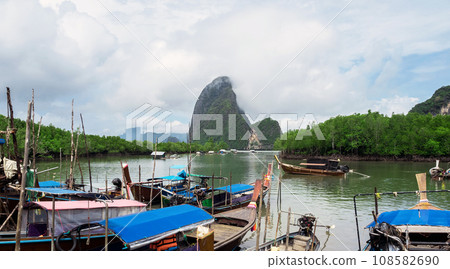 Cloudy morning at Fishing villages with long tail boat ,mangrove forest and island Cloudy morning at Fishing villages with long tail boat ,mangrove forest and island 108582690