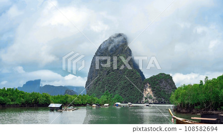 Cloudy morning at Fishing villages with long tail boat ,mangrove forest and island 108582694