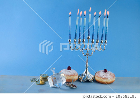 Jewish holiday Hanukkah with menorah, traditional Candelabra, donut and dreidel, spinning top. Jewish holiday Hanukkah with menorah, traditional Candelabra, donut and dreidel, spinning top. 108583193