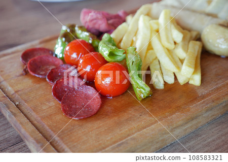 salami sausage served with tomato, chips and mushroom salami sausage served with tomato, chips and mushroom 108583321
