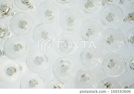 A lot of empty wine glasses. Row of clean glass transparent glasses are on a table on banquet in a bar 108583606