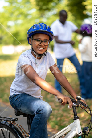 Kids spending time with dad and learning to ride a bike Kids spending time with dad and learning to ride a bike 108584214