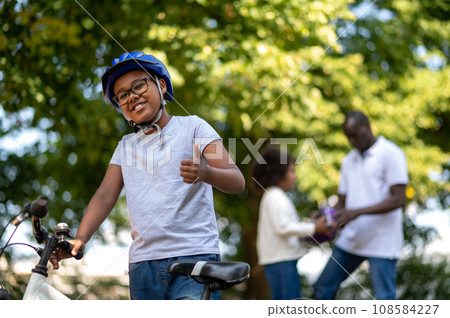 Kids spending time with dad and learning to ride a bike Kids spending time with dad and learning to ride a bike 108584227