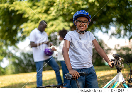 Kids spending time with dad and learning to ride a bike Kids spending time with dad and learning to ride a bike 108584234
