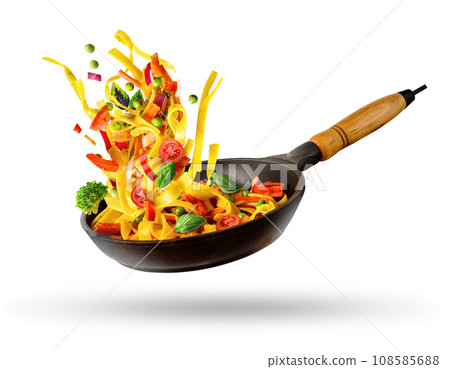 Cooking Italian pasta with vegetables flying over a hot frying pan isolated in white. 108585688