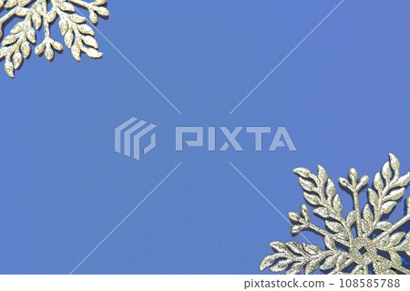 Christmas background with snowflakes. On a blue background two silver-white snowflakes with sparkles are laid out. Happy New Year. Merry Christmas. Postcard or invitation. Copy space. Flat lay. 108585788