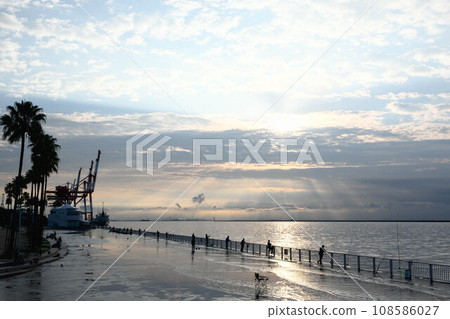The sun's rays reach the sea from the early morning clouds. Photographed at Rokko Island Marine Park, Kobe City, Hyogo Prefecture. 108586027