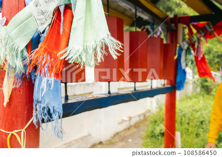 Rotating religious elements for touching turning spinning Buddhist prayer wheel at Buddhist monastery. Prayer wheels in Buddhist stupa temple. Buddhism religion concept 108586450