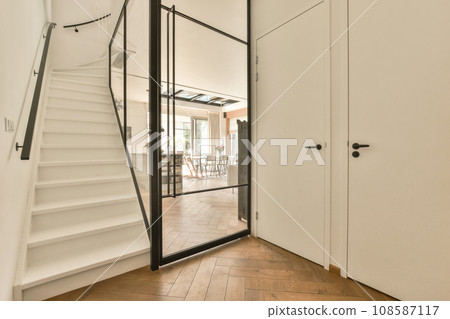 the inside of a house with wood flooring and white walls, stairs leading up to an open door that leads to another room 108587117