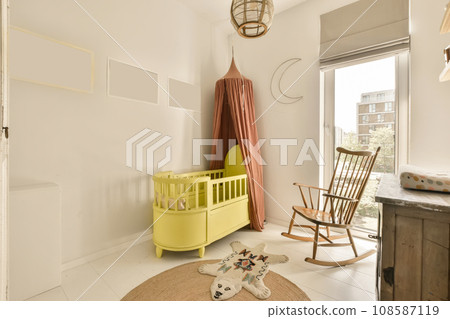 a baby's room with a rocking chair, cribt and other items on the floor in it a baby's room with a rocking chair, cribt and other items on the floor in it 108587119