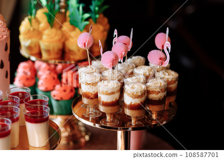 birthday exitic catering, table with modern desserts, cupcakes, sweets with fruits. delicious candy bar at expensive birthday party. space for text. baby shower. holiday celebration 108587701