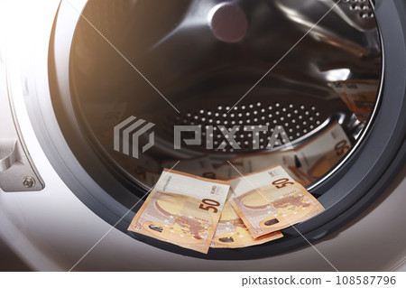 Euro money banknotes in washing machine - illegal cash 50 and mafia money laundering - tax evasion in Europe inflation and impairment. money laundering concept - euro banknotes in washing mashine Euro money banknotes in washing machine - illegal cash 50 and mafia money laundering - tax evasion in Europe inflation and impairment. money laundering concept - euro banknotes in washing mashine 108587796