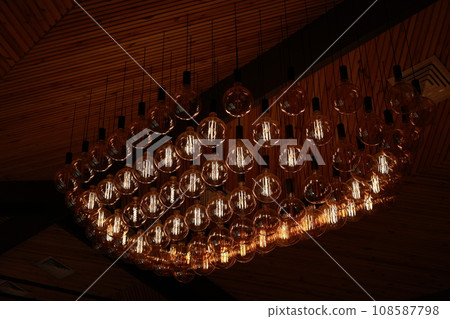 Stylish, modern and decorative lamps of Edison of round shape in the rows. Light bulbs in retro style. A lot celling glowing vintage LED lamps. Object for interior decoration, selective focus photo Stylish, modern and decorative lamps of Edison of round shape in the rows. Light bulbs in retro style. A lot celling glowing vintage LED lamps. Object for interior decoration, selective focus photo 108587798