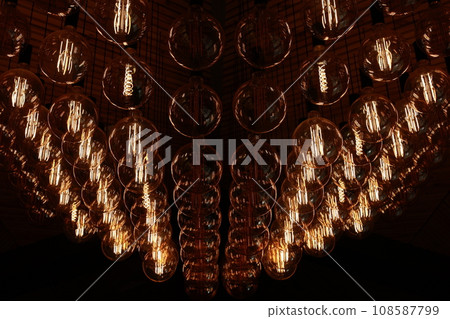 Stylish, modern and decorative lamps of Edison of round shape in the rows. Light bulbs in retro style. A lot celling glowing vintage LED lamps. Object for interior decoration, selective focus photo Stylish, modern and decorative lamps of Edison of round shape in the rows. Light bulbs in retro style. A lot celling glowing vintage LED lamps. Object for interior decoration, selective focus photo 108587799