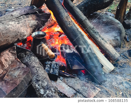 Brew coffee in a Turk on an open fire. Brew coffee in a Turk on an open fire. 108588135