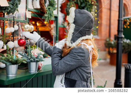 woman is walking in park or on ice rink. happy woman at Christmas market buying gifts and having fun woman is walking in park or on ice rink. happy woman at Christmas market buying gifts and having fun 108588282