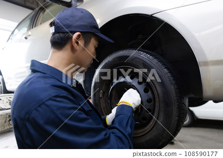 Auto mechanic inspecting a car Auto mechanic inspecting a car 108590177