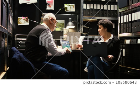Inspectors team reading case files to conduct private investigation, clandestine operation. Experienced officer and criminal expert discussing about crime suspect, detective work. Inspectors team reading case files to conduct private investigation, clandestine operation. Experienced officer and criminal expert discussing about crime suspect, detective work. 108590648