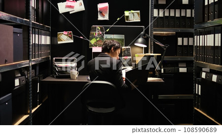 Agent analyzing clues on board in police agency incident room, using new details and forensic report to build strong culprit profile. Criminal expert reading wintess statements, gathering information. Agent analyzing clues on board in police agency incident room, using new details and forensic report to build strong culprit profile. Criminal expert reading wintess statements, gathering information. 108590689