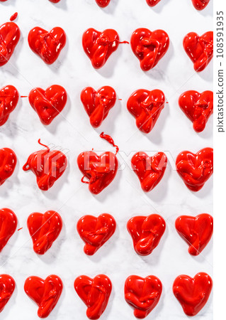 Piping melted chocolate from piping back over the parchment paper to make a chocolate heart. Piping melted chocolate from piping back over the parchment paper to make a chocolate heart. 108591935