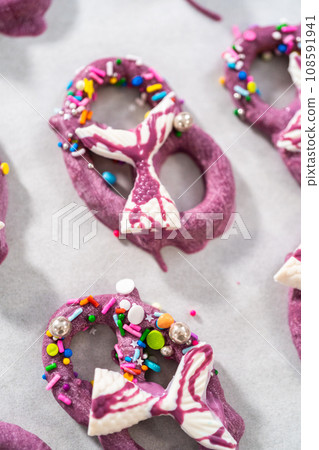 Decorating chocolate-dipped pretzels twists with chocolate mermaid tails. Decorating chocolate-dipped pretzels twists with chocolate mermaid tails. 108591941