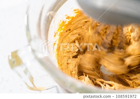 Whipping ingredients in a stand electric mixer to make dulce de leche buttercream frosting. 108591972