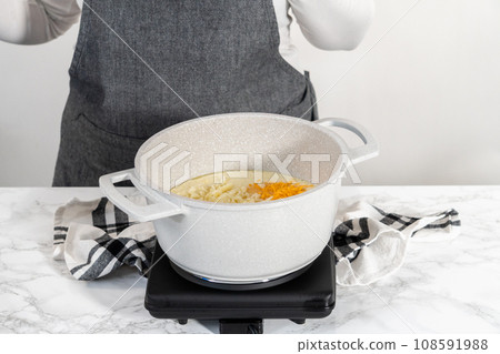 Cooking cheesy sauce in a cooking pot to prepare macaroni and cheese with broccoli. Cooking cheesy sauce in a cooking pot to prepare macaroni and cheese with broccoli. 108591988