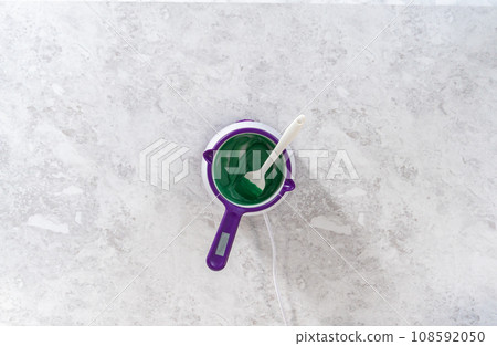 Flat lay. Melting chocolate chips in a candy melting pot to make chocolate carrot cake toppers. 108592050