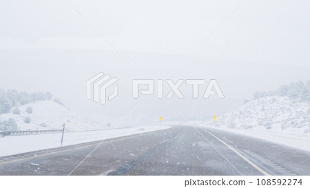 POV-Electric vehicle is captured deftly navigating the I-70 highway during a winter storm in Western Colorado. 108592274