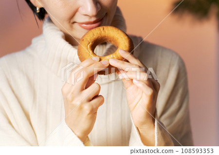 Woman in her 30s eating a donut Woman in her 30s eating a donut 108593353