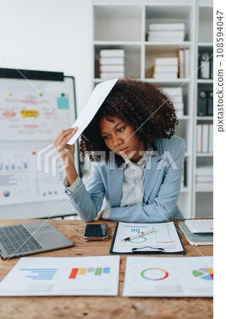 Burnout American African business woman in stress works with many paperwork document, migraine attack, Freelance, work at office. Burnout American African business woman in stress works with many paperwork document, migraine attack, Freelance, work at office. 108594047