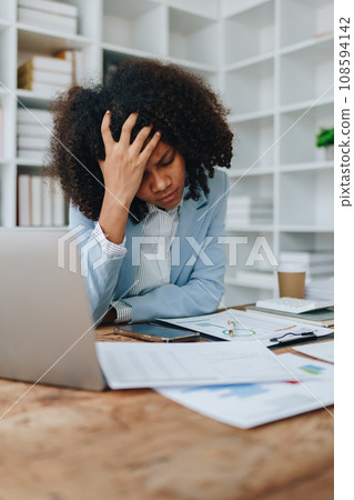 Burnout American African business woman in stress works with many paperwork document, migraine attack, Freelance, work at office. 108594142
