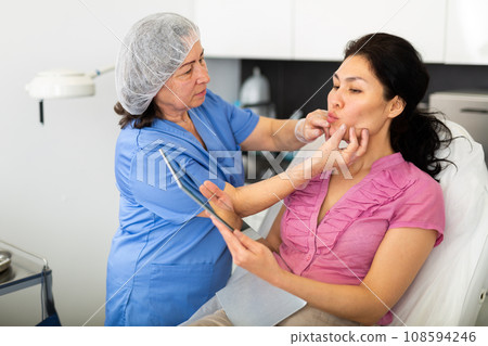 Experienced cosmetology doctor in the clinic does a mechanical facial cleaning a young female client 108594246