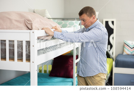 Man stands in childrens furniture section of store, admiring colorful and playful designs 108594414