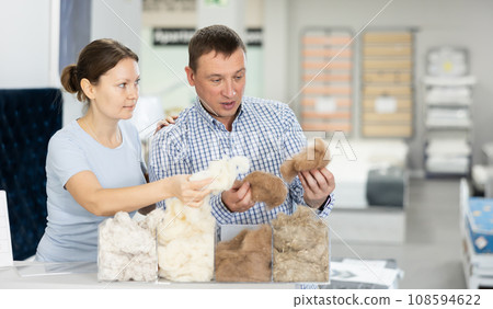 Couple examines samples of mattress fillers in furniture store Couple examines samples of mattress fillers in furniture store 108594622