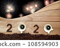 Coffee beans and hot fresh coffee in a white cup with foam and text number design 2024 for Happy New Year Concept. with fireworks background. 108594903