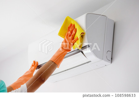 Asian man cleaning air conditioner with microfiber cloth Asian man cleaning air conditioner with microfiber cloth 108598633