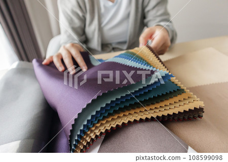 female designer with fabric color samples choosing textile for curtains 108599098