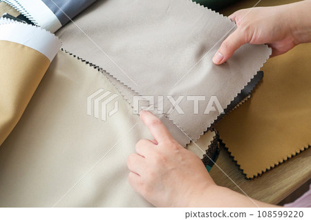 female designer with fabric color samples choosing textile for curtains female designer with fabric color samples choosing textile for curtains 108599220