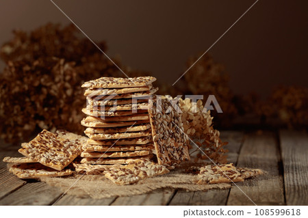 Crackers with sunflower and flax seeds on an old wooden table. Crackers with sunflower and flax seeds on an old wooden table. 108599618