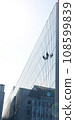Workers cleaning the windows of a high-rise building 108599839