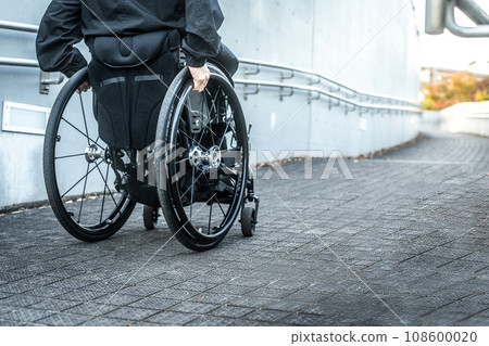 Wheelchair user climbing the slope 108600020