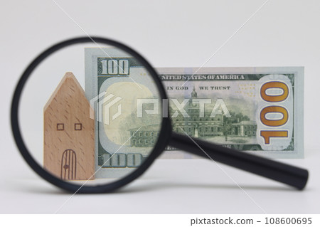 View of a house and a banknote through a magnifying glass, real estate purchase and insurance View of a house and a banknote through a magnifying glass, real estate purchase and insurance 108600695