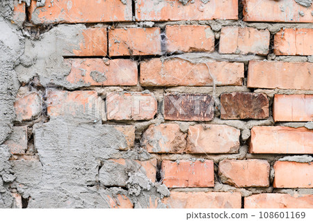 The background of the wall is made of brown bricks, laid out from a cement-sand mortar The background of the wall is made of brown bricks, laid out from a cement-sand mortar 108601169