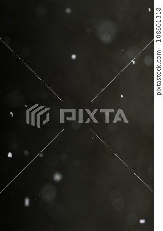 Bokeh of white snow on a black background. Snowfall - design element. 108601318